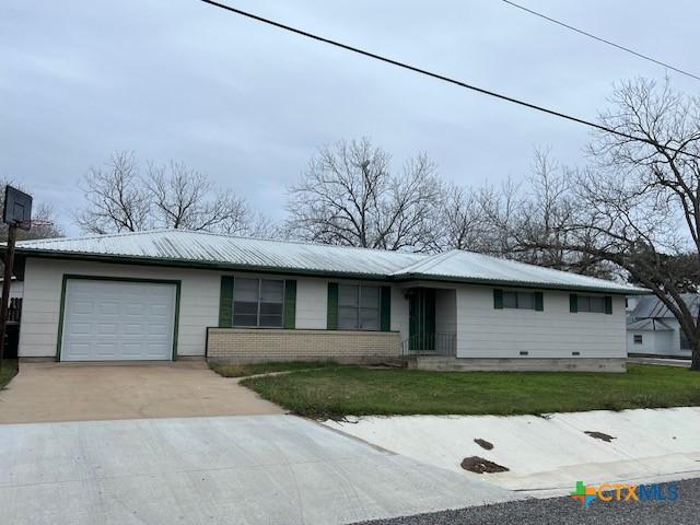 single story home featuring a garage and a front lawn