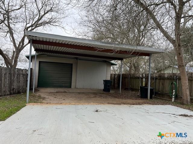 view of outdoor structure featuring fence and an outbuilding