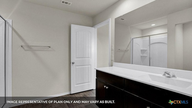 bathroom featuring hardwood / wood-style flooring, vanity, and walk in shower