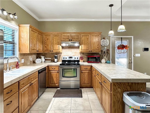 720 E Travis St, Luling, TX 78648 - kitchen with stainless steel appliances, under cabinet range hood, a peninsula, decorative backsplash, and ornamental molding