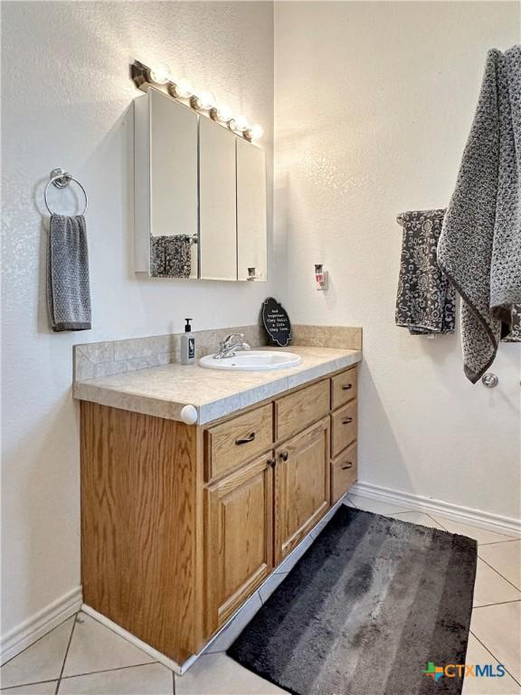 720 E Travis St, Luling, TX 78648 - bathroom with vanity and tile patterned flooring