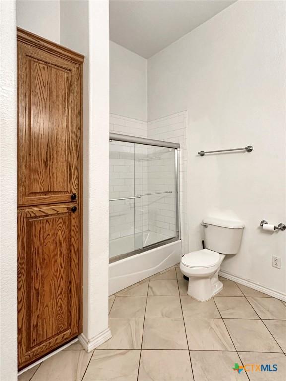 720 E Travis St, Luling, TX 78648 - full bath with enclosed tub / shower combo and tile patterned floors