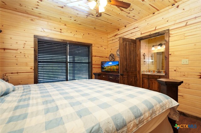 bedroom with connected bathroom, wooden walls, sink, wooden ceiling, and ceiling fan