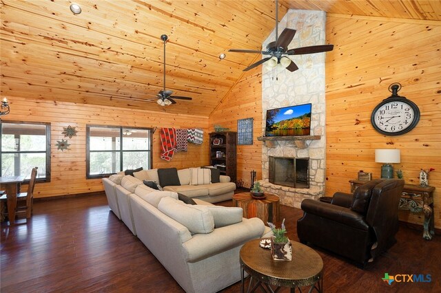 living room featuring wood walls, high vaulted ceiling, a fireplace, wood ceiling, and dark wood-type flooring