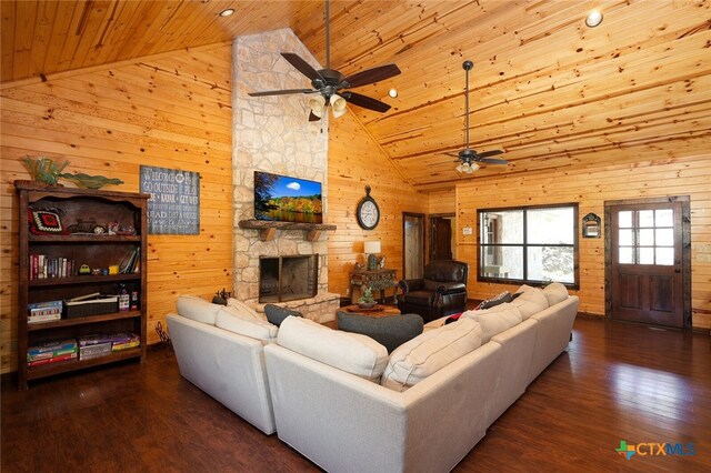 living room with a stone fireplace, dark wood-type flooring, wooden walls, wooden ceiling, and high vaulted ceiling