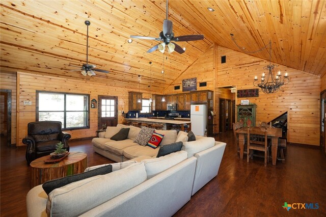 living room with ceiling fan with notable chandelier, wood ceiling, wood walls, high vaulted ceiling, and dark hardwood / wood-style floors