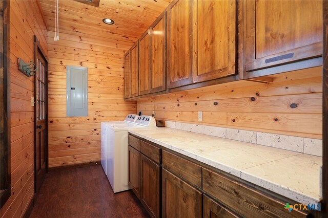 laundry room with electric panel, cabinets, wood walls, and dark wood-type flooring