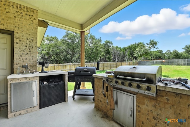 15933 Salado Dr, Temple, TX 76502 - fenced backyard with exterior kitchen, a patio, and view of scattered trees