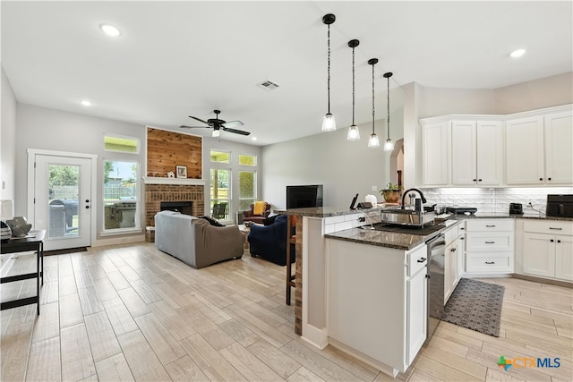 15933 Salado Dr, Temple, TX 76502 - kitchen with ceiling fan, a peninsula, a breakfast bar, light wood finished floors, and dark stone countertops
