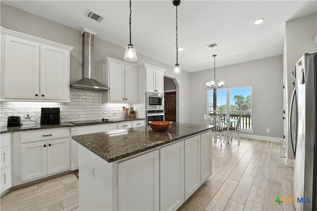 15933 Salado Dr, Temple, TX 76502 - kitchen featuring wall chimney range hood, appliances with stainless steel finishes, a chandelier, backsplash, and a center island