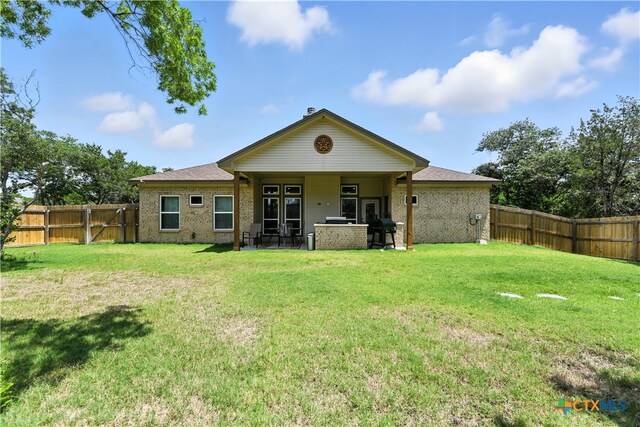 15933 Salado Dr, Temple, TX 76502 - back of house with a fenced backyard, brick siding, and french doors