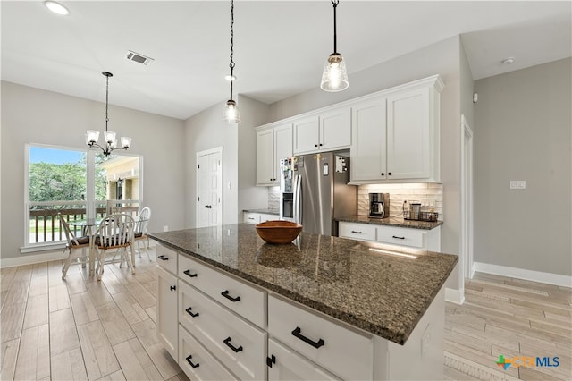 15933 Salado Dr, Temple, TX 76502 - kitchen with stainless steel fridge with ice dispenser, light wood-style flooring, decorative backsplash, a chandelier, and white cabinetry