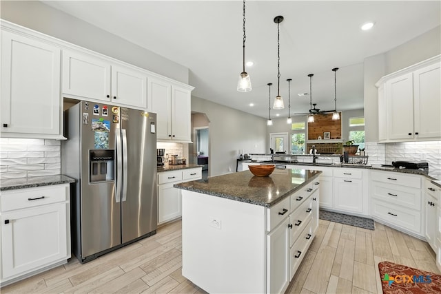 15933 Salado Dr, Temple, TX 76502 - kitchen featuring stainless steel fridge, arched walkways, tasteful backsplash, a peninsula, and a kitchen island