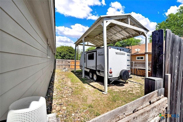 exterior space featuring a detached carport and fence