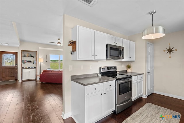 1975 Taylorsville Rd, Red Rock, TX 78662 - kitchen with dark wood finished floors, dark countertops, visible vents, and stainless steel appliances