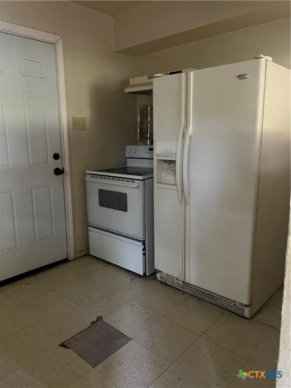 410 Railroad St, San Marcos, TX 78666 - kitchen with white appliances and light tile patterned flooring