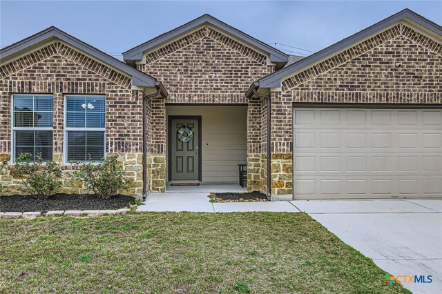 ranch-style home with a front lawn, concrete driveway, brick siding, and a garage