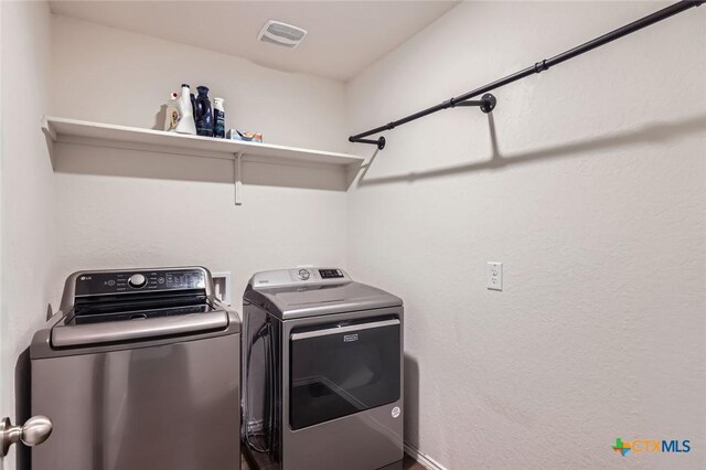 laundry area with laundry area, independent washer and dryer, and visible vents