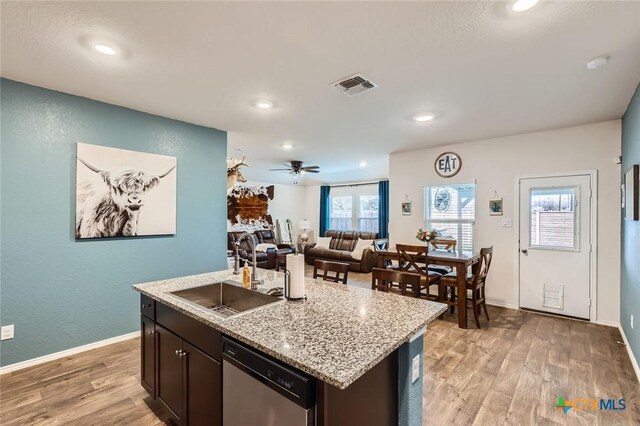 kitchen with a sink, visible vents, dishwasher, and light wood-style flooring