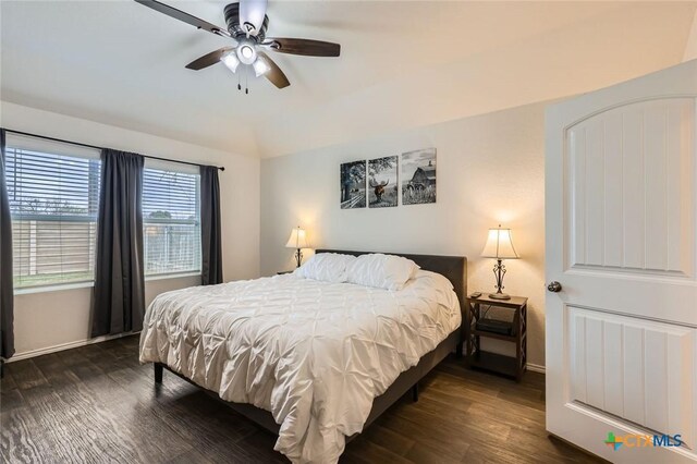 bedroom featuring a ceiling fan, lofted ceiling, baseboards, and dark wood-style flooring