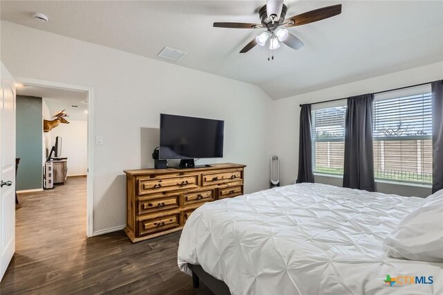 bedroom with visible vents, baseboards, dark wood-style flooring, ceiling fan, and vaulted ceiling