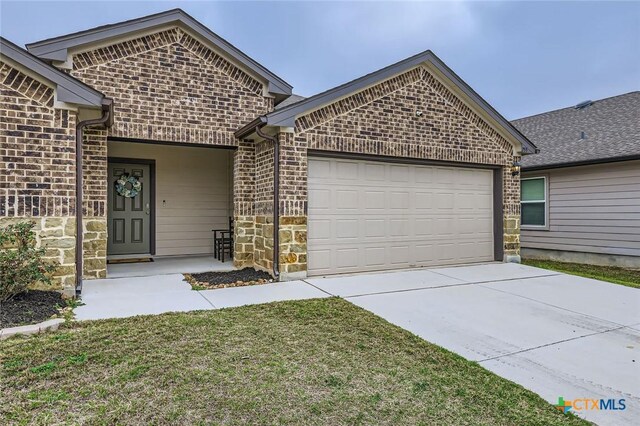 view of front facade featuring stone siding, driveway, brick siding, and an attached garage