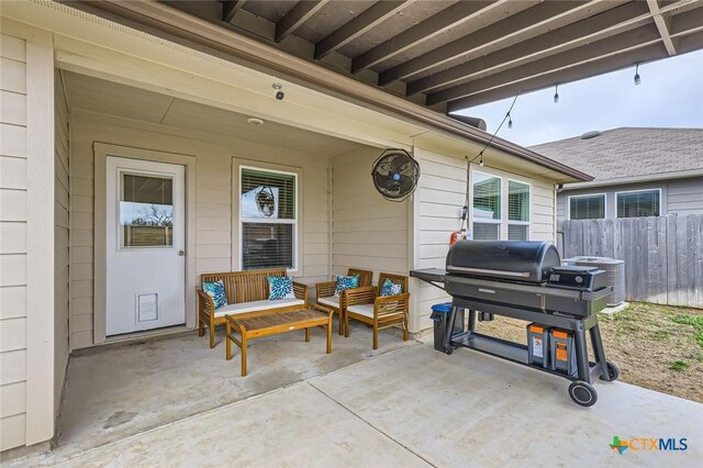 view of patio with fence and a grill