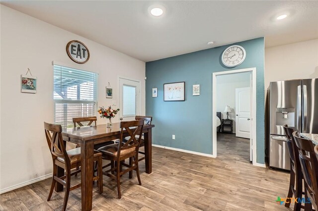 dining space featuring light wood finished floors, recessed lighting, and baseboards