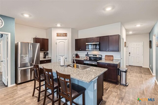 kitchen with dark brown cabinetry, appliances with stainless steel finishes, and a sink