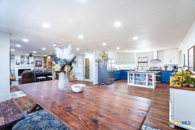 dining area featuring ceiling fan, dark hardwood / wood-style flooring, sink, and a textured ceiling