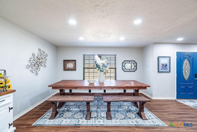 dining room with dark hardwood / wood-style flooring and a textured ceiling