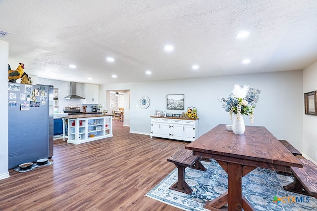 dining area featuring hardwood / wood-style flooring and a textured ceiling