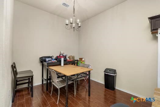 dining space featuring dark hardwood / wood-style floors and an inviting chandelier