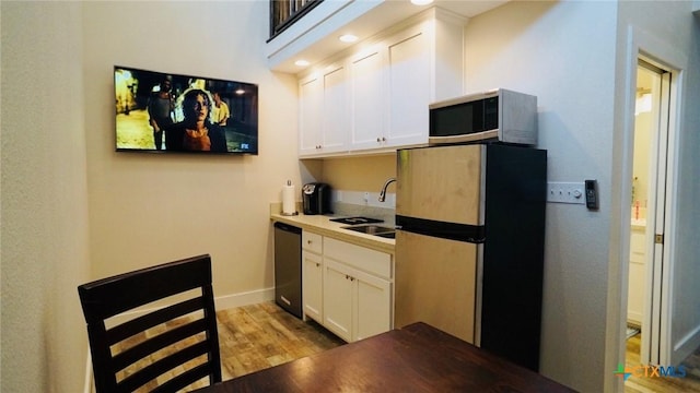 1206 W Commerce St, Port Oconnor, TX 77982 - kitchen featuring light wood-style flooring, a sink, freestanding refrigerator, white cabinets, and dishwasher