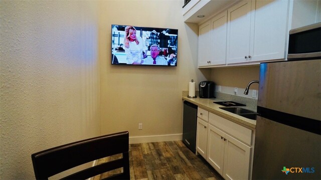 1206 W Commerce St, Port Oconnor, TX 77982 - kitchen featuring a sink, stainless steel appliances, dark wood-style floors, white cabinets, and baseboards