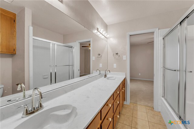 full bathroom featuring enclosed tub / shower combo, toilet, tile patterned floors, vanity, and ceiling fan