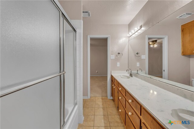 bathroom with tile patterned flooring, vanity, ceiling fan, and combined bath / shower with glass door