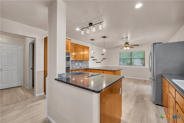 kitchen with a kitchen island, light wood-type flooring, appliances with stainless steel finishes, decorative light fixtures, and decorative backsplash