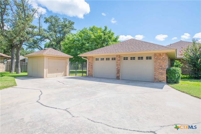 view of front of home with a garage and an outbuilding