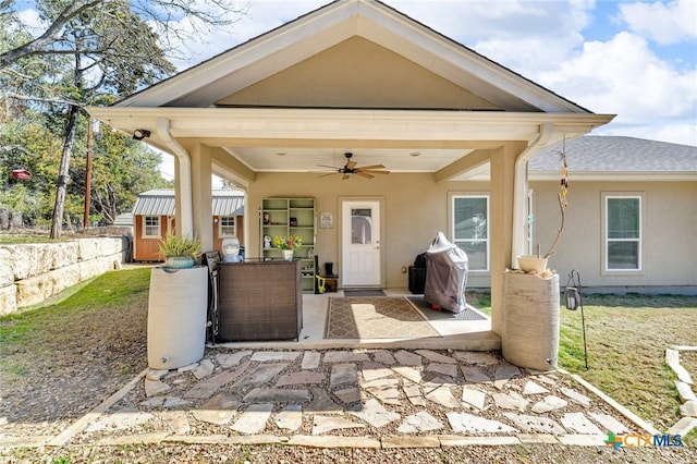 exterior space with ceiling fan and a patio area