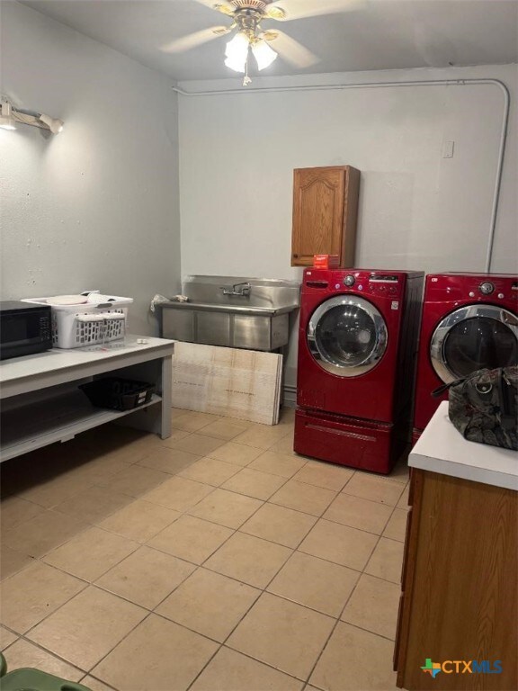 laundry room featuring separate washer and dryer, a ceiling fan, and cabinet space
