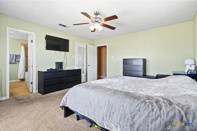 bedroom featuring baseboards, carpet, visible vents, and a textured ceiling