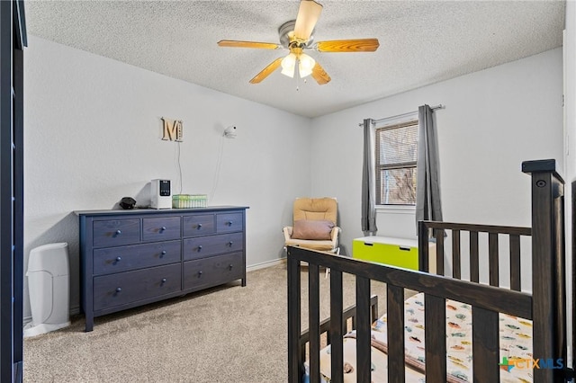 bedroom featuring baseboards, light colored carpet, a textured ceiling, and ceiling fan