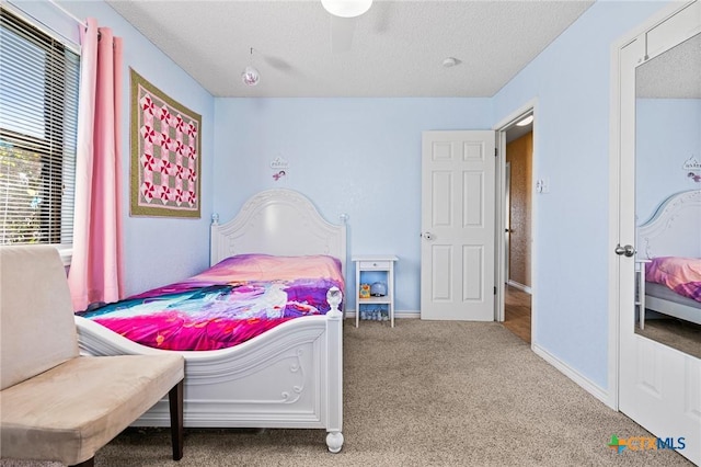 bedroom with baseboards, carpet floors, and a textured ceiling