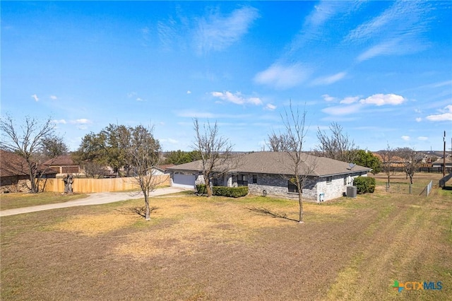 ranch-style home with a front yard, an attached garage, driveway, and fence