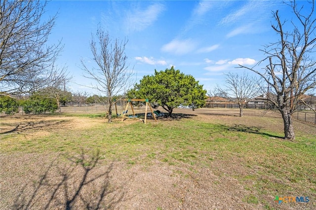 view of yard featuring a rural view, a playground, and fence