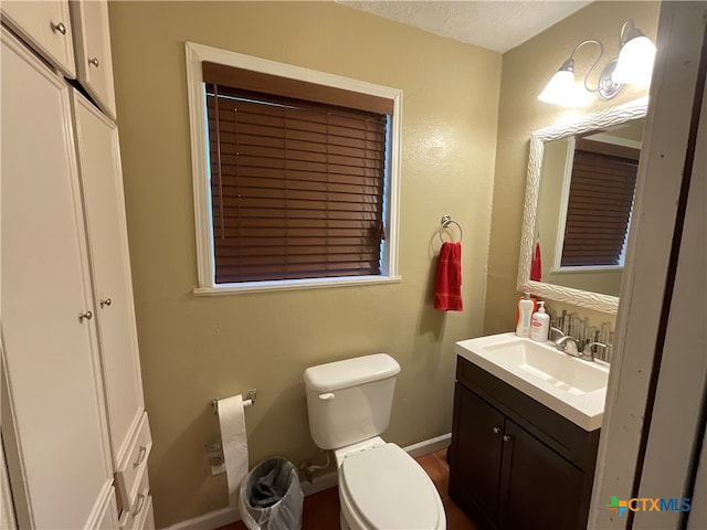 bathroom featuring vanity, toilet, and a textured ceiling