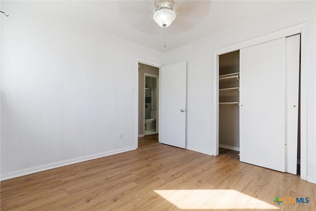 unfurnished bedroom featuring a closet, a ceiling fan, baseboards, and wood finished floors