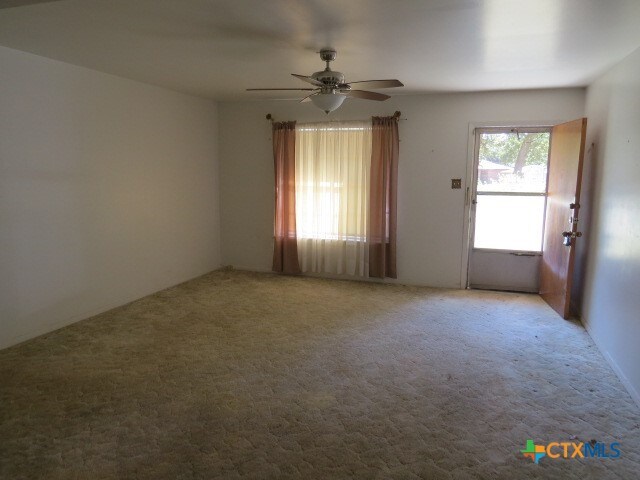 spare room featuring carpet and ceiling fan