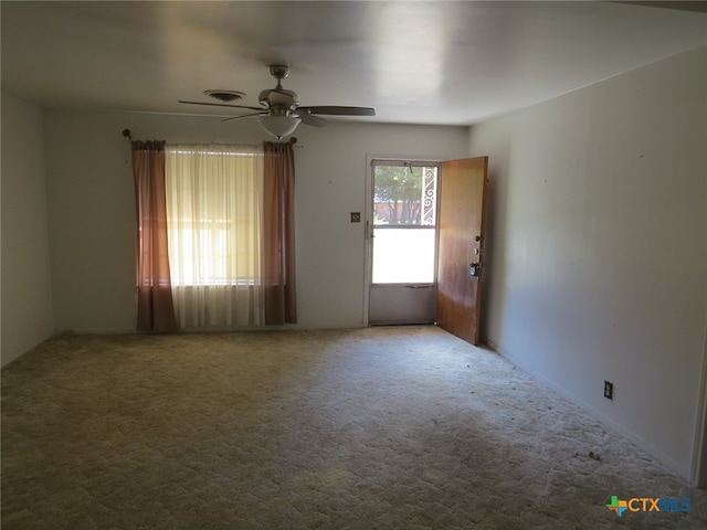 carpeted spare room with ceiling fan